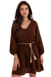 Woman wearing a brown dress with a belt on a white background