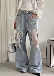 Person wearing light blue jeans with lace patches in a minimal indoor setting