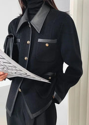 Person wearing a black coat with gray collar and buttons, holding a newspaper.