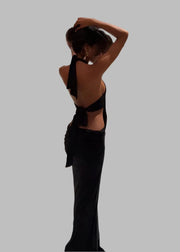 Woman in a black dress standing on a staircase in an elegant interior setting