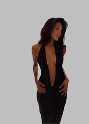 Woman in a black dress standing on a staircase in an elegant interior setting