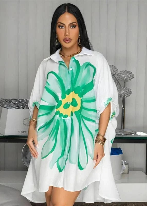 Woman wearing a white dress with a large green floral design indoors.