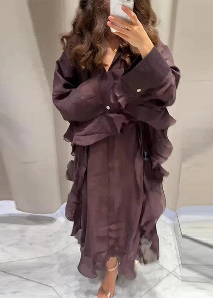 Person wearing a long, dark brown ruffled dress in a bathroom setting.