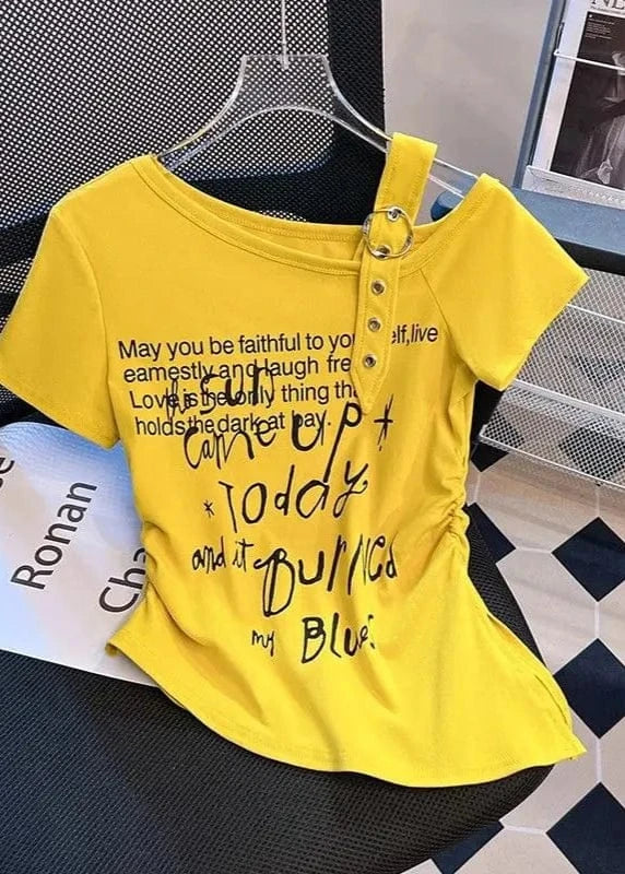 Yellow t-shirt with text on a chair with a newspaper in the background