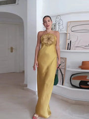 Woman in a yellow strapless dress with a floral embellishment in an indoor setting.