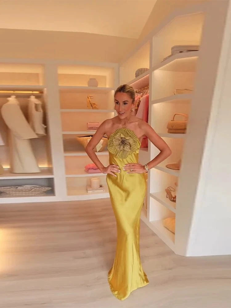 Woman in a yellow evening gown standing in a well-lit closet.