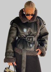 Woman wearing a black leather coat with fur trim in an urban setting