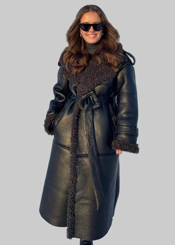 Woman wearing a black leather coat with fur trim in a snowy landscape