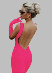 Woman in a bright pink dress with a car in the background