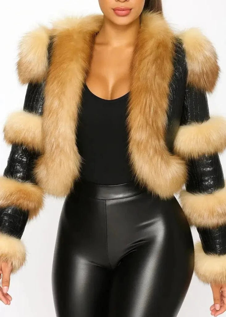 Person wearing a black leather jacket with beige fur trim on a white background