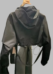 Black raincoat on a hanger in a store setting