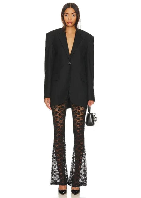 Woman wearing a black blazer and lace pants on a white background