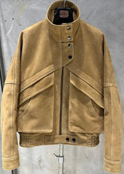 Tan leather jacket on a stand against a gray concrete wall