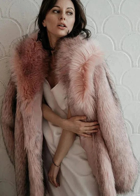 Woman wearing a pink fur coat against a textured wall.
