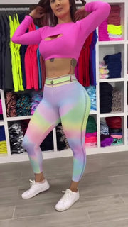 Person wearing a bright pink top and colorful leggings in a store setting.