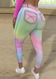 Pastel tie-dye leggings with a pink pocket worn by a person on a wooden floor.