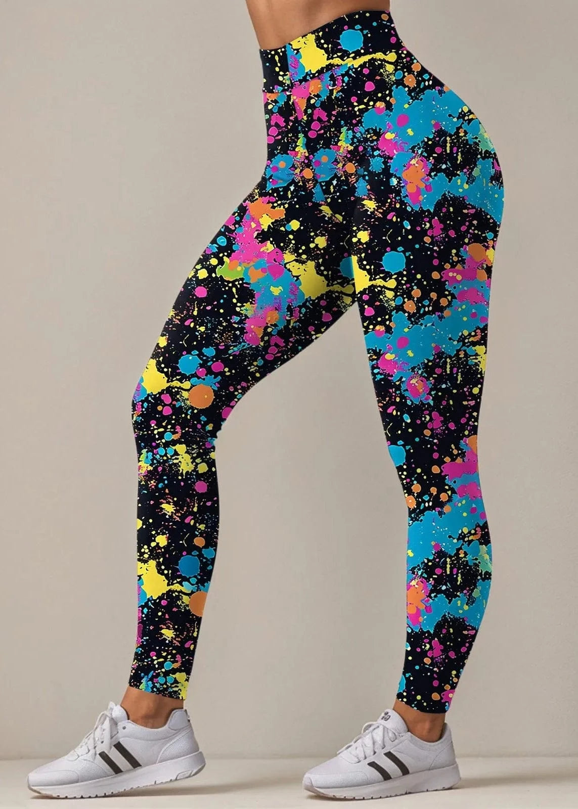 Colorful splatter-patterned leggings worn by a person on a neutral background
