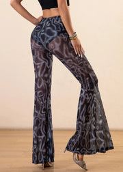 Person wearing patterned flared pants on a plain background