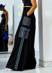 Black wide-leg pants with colorful striped pockets worn by a person indoors.