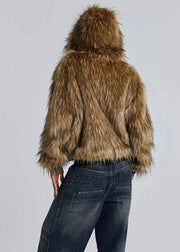 Person wearing a brown fur coat on a plain background