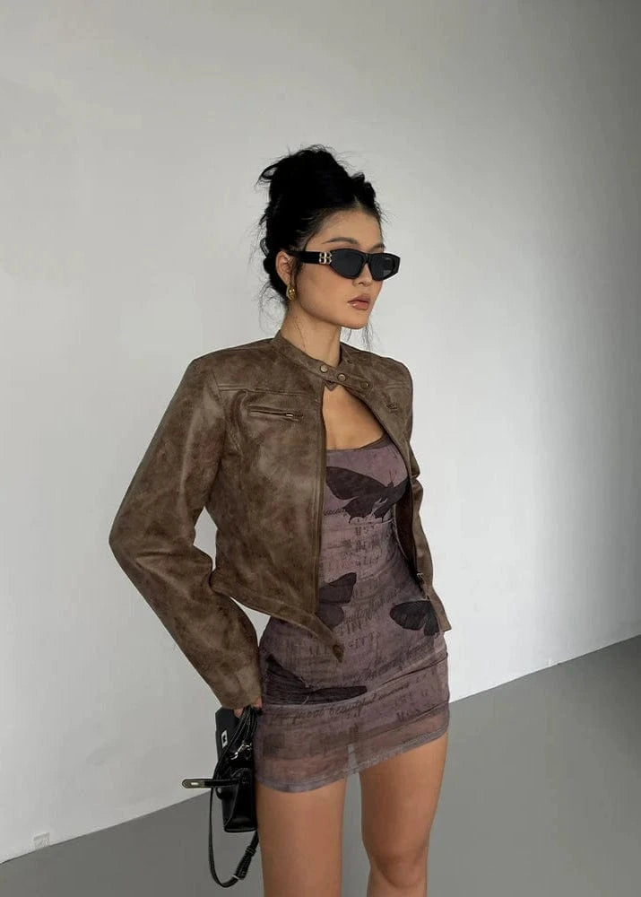 Woman wearing a brown jacket and matching dress against a plain background