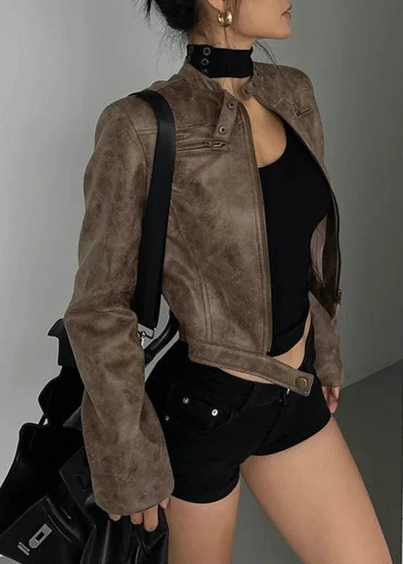 Person wearing a brown suede jacket and black outfit against a neutral background