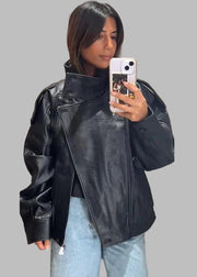 Person wearing a black leather jacket taking a mirror selfie.
