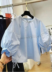 Light blue jacket with puff sleeves on a hanger in a store setting