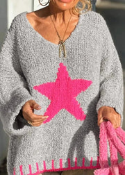 Person wearing a gray sweater with a pink star design, holding a matching pink bag.