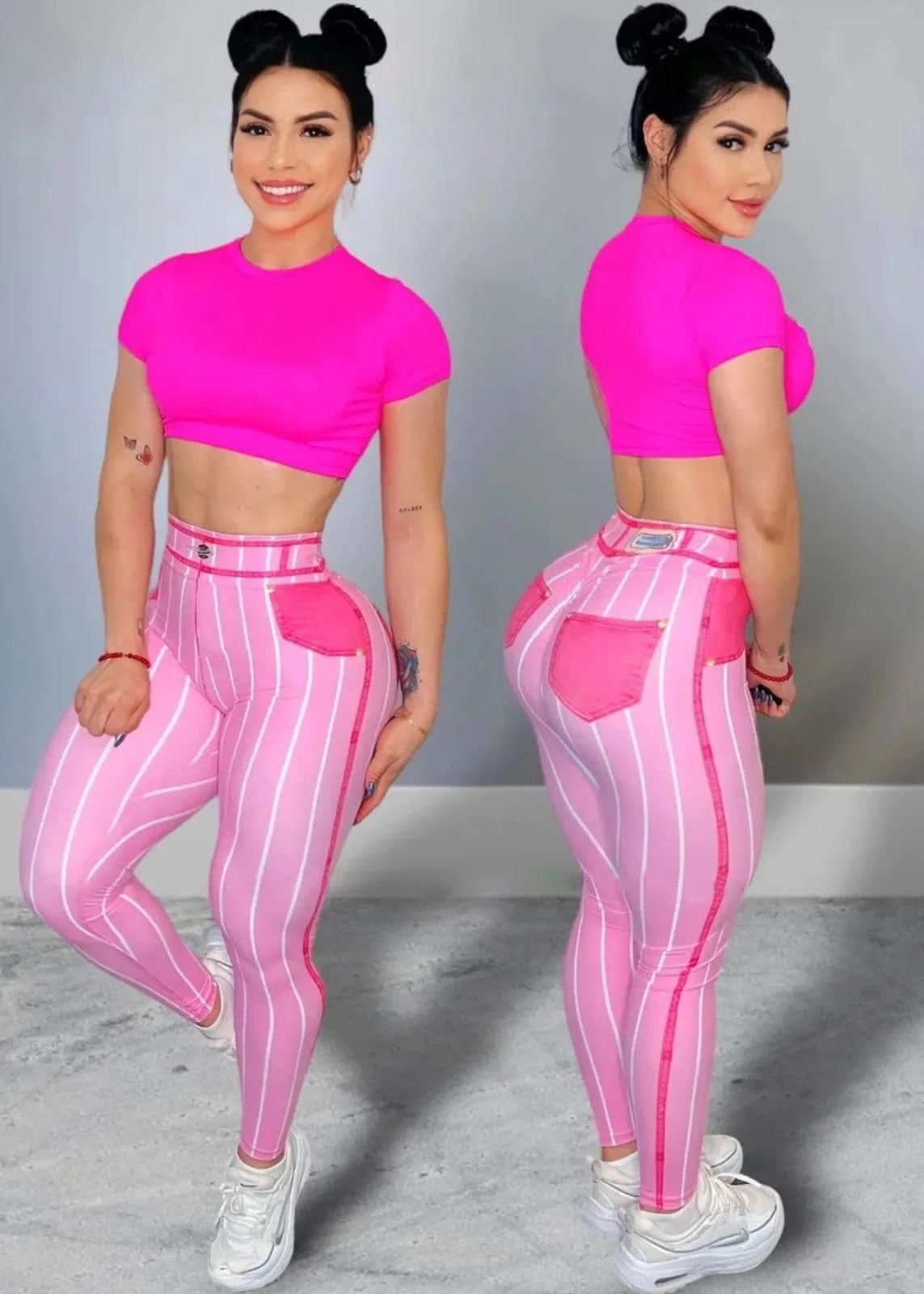 Woman wearing a pink crop top and striped leggings posing against a gray background
