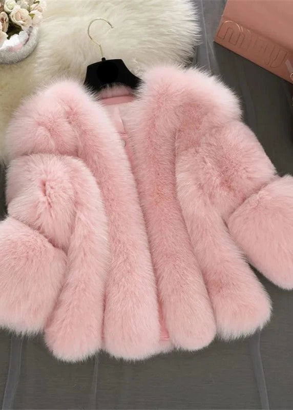 Pink faux fur coat on a hanger with a blurred background