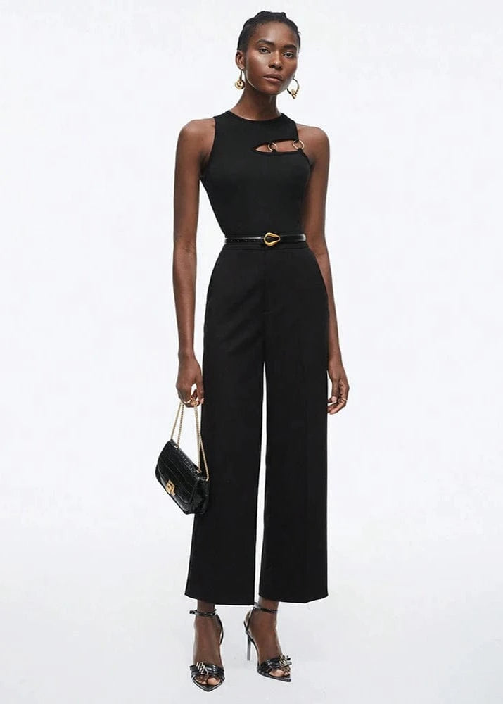 Woman wearing a black jumpsuit with cut-out design on a white background