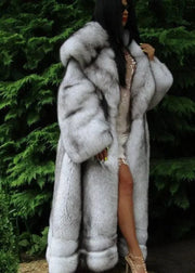Person wearing a fur coat with a green foliage background