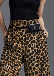 Person wearing leopard print pants with a black top on a gray background