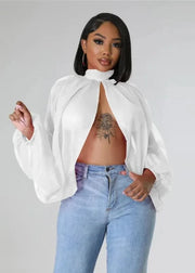 Woman wearing a white blouse and blue jeans against a gray background