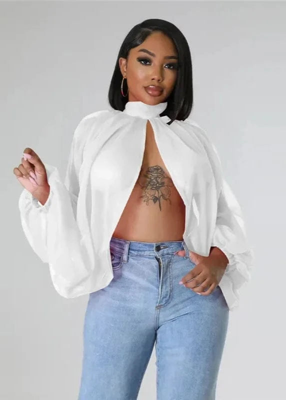 Woman wearing a white blouse and blue jeans against a gray background