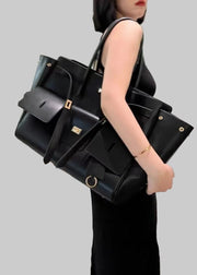 Woman holding a large black handbag in an indoor setting