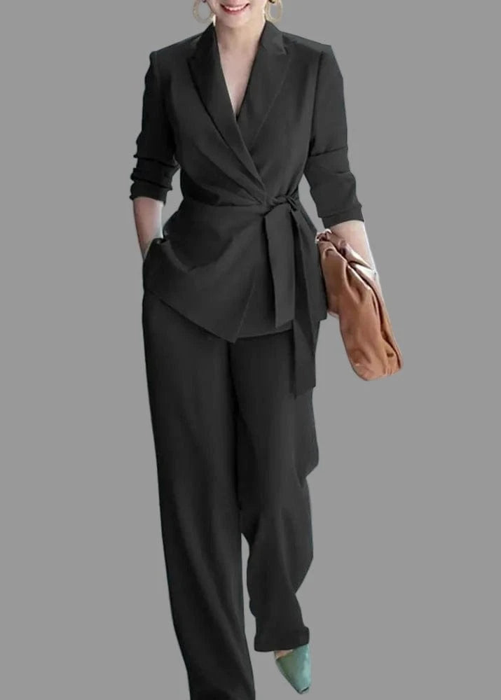 Woman in a black suit holding a brown bag in an urban setting