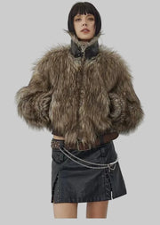 Person wearing a fur jacket and black leather skirt against a white background