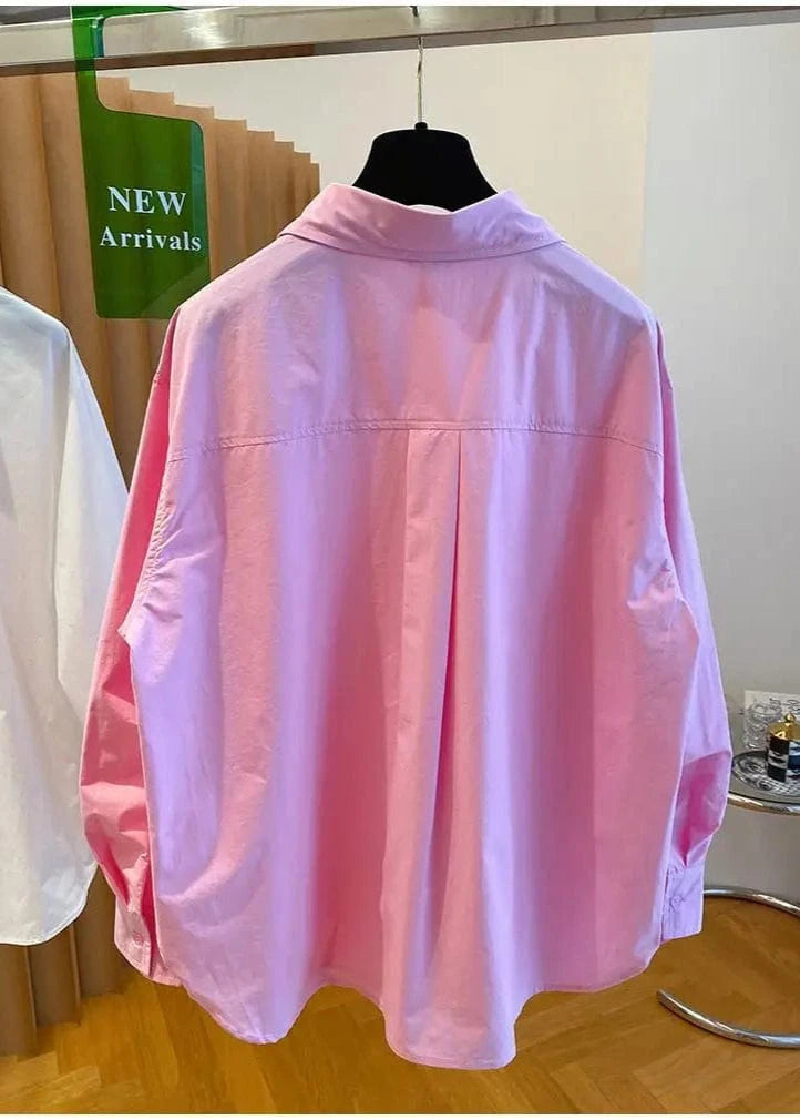 Pink shirt on a mannequin in a store setting with 'NEW Arrivals' sign.