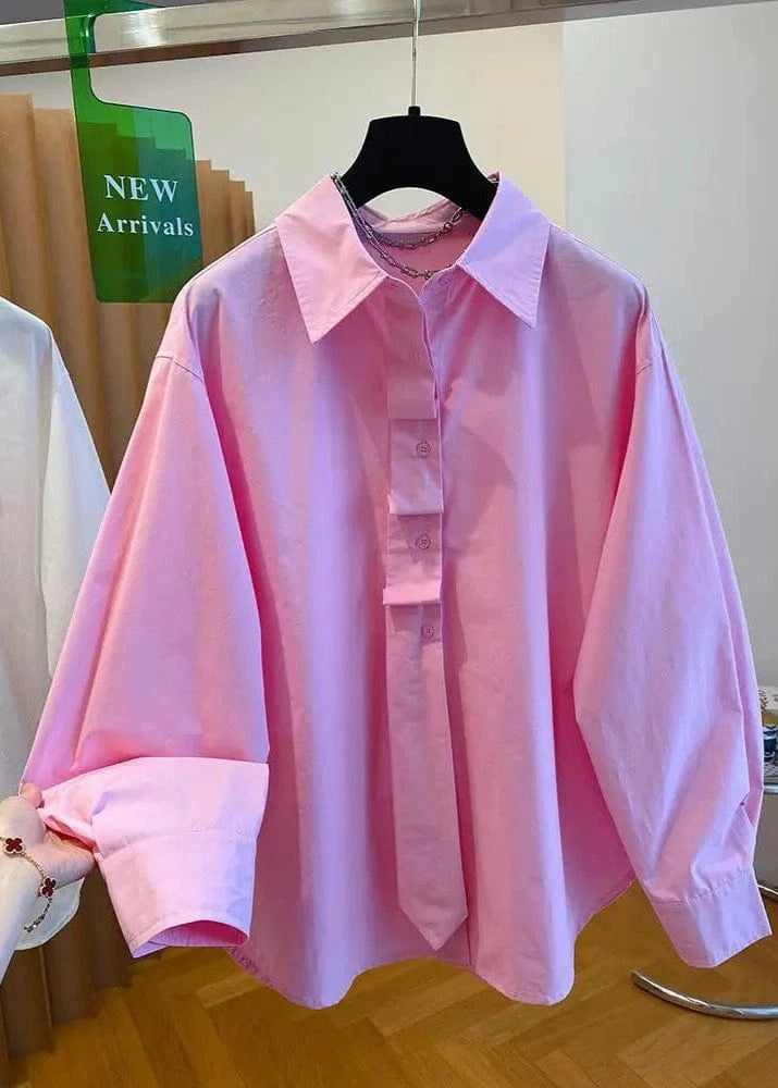 Pink shirt on a hanger with a 'NEW Arrivals' sign in the background