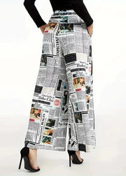 Wide-leg pants with a newspaper print worn by a person on a white background