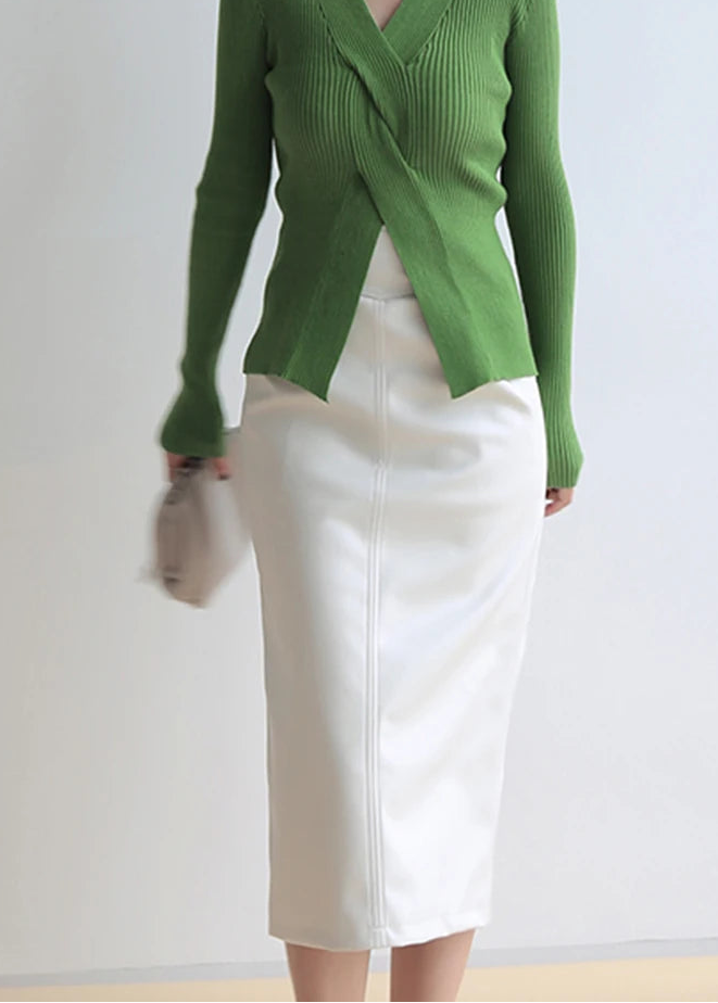 Green knitted cardigan and white skirt on a plain background with 'Nerazzurri' branding.