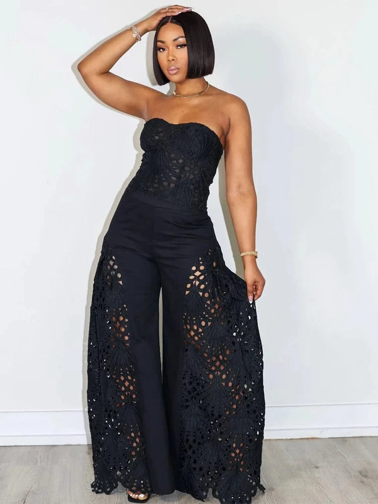 Woman wearing a black lace jumpsuit against a white background