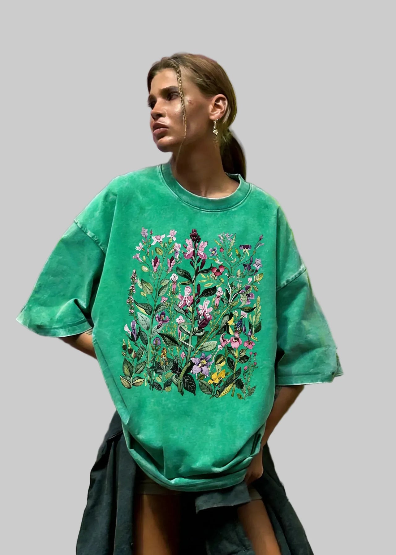 Person wearing a green t-shirt with floral design against a colorful background