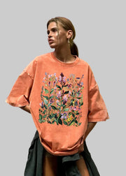 Person wearing a floral-patterned peach t-shirt against a colorful geometric background