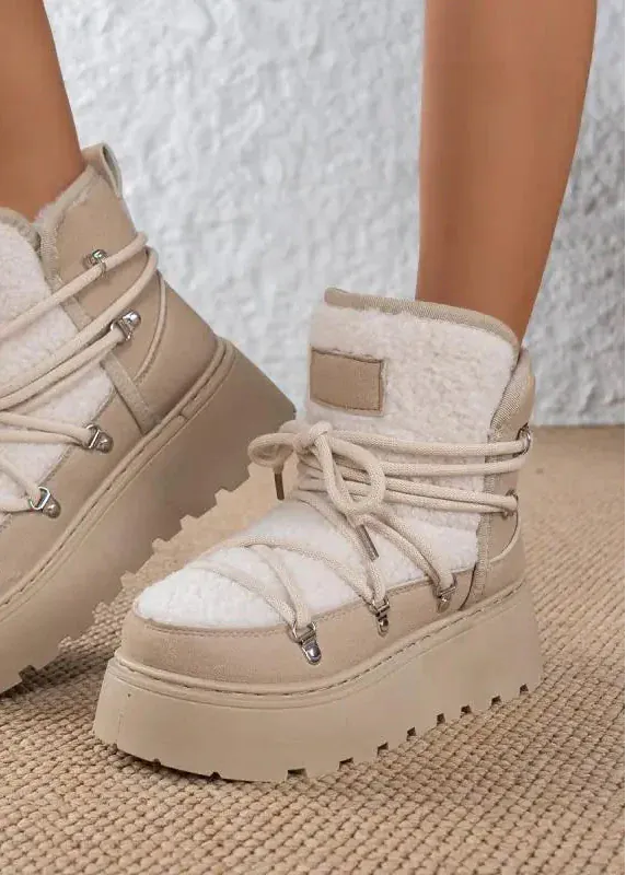 Beige winter boots with white fur lining on a textured surface