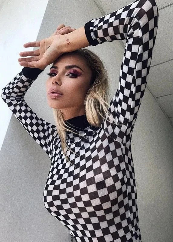 Person wearing a black and white checkered outfit indoors.