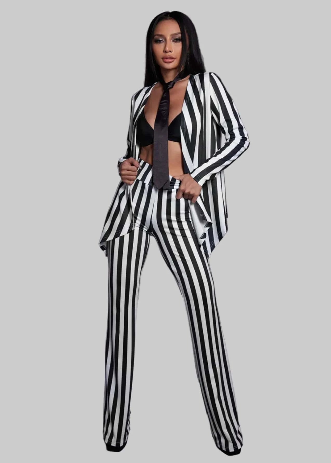 Woman wearing a black and white striped suit with a dark background