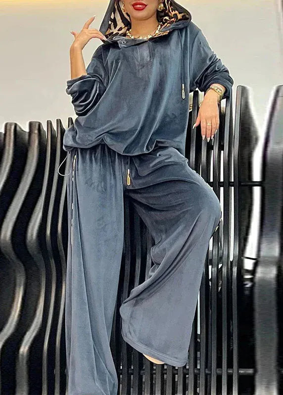 Woman wearing a blue tracksuit sitting on a black metal bench.